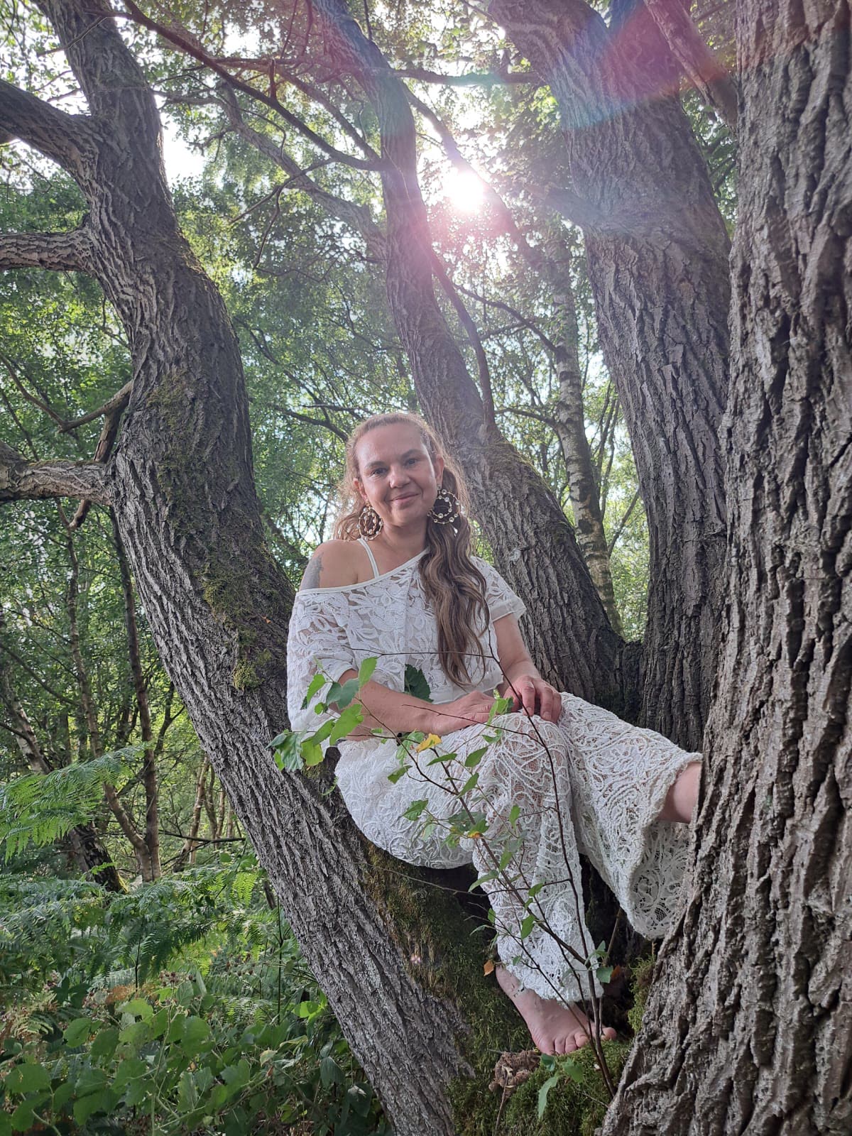 Aynaz in white lace, seated in the branches of an old tree